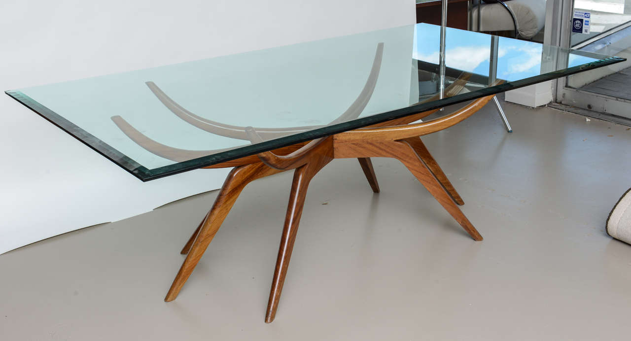 the glass top above a mahogany frame with6 curved supports above scissor tapering legs- literature- Il Mobile D'Italiano Degli Anni 40s e 50s, de guttry