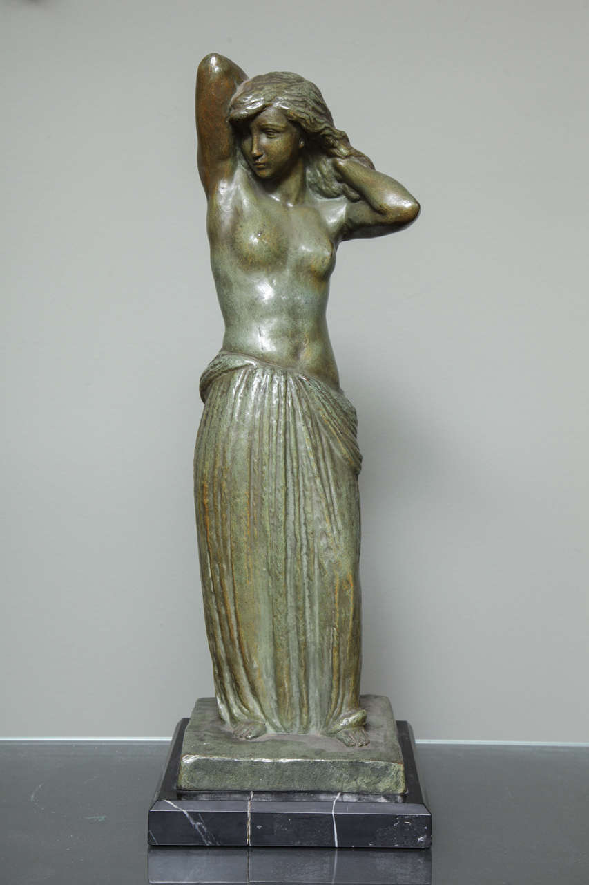 Georges Gori,
"The Model," a green patinated bronze sculpture depicting a bare-breasted female standing with hands behind her head, mounted on a marble base.
        