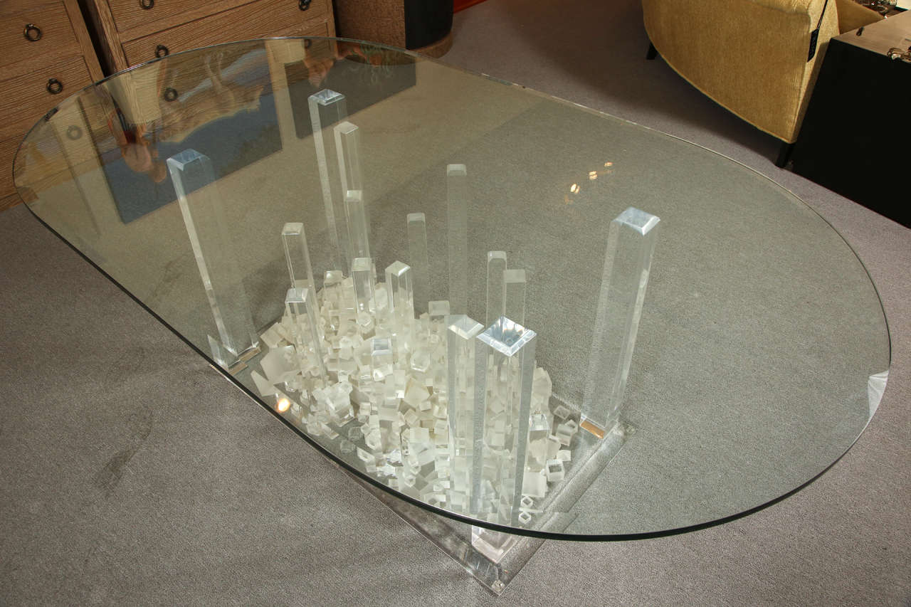 This lucite dining table is made up of large rectangle forms with an array of small lucite cube forms. the table has a large oval
 3/4
