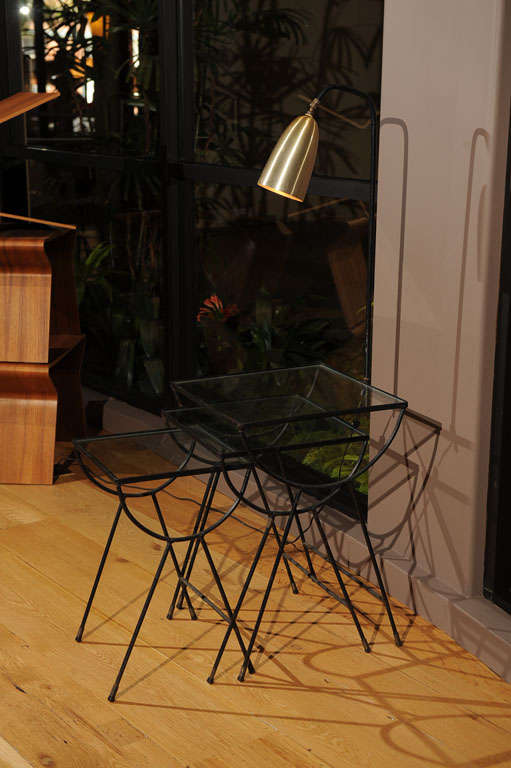 A nesting table made of glass and metal with a connected brass lamp.  Often attributed to Arbuck and a line designed for them by George Nelson but in fact that may not be the case but still a very hip piece of 50's era furniture... 
