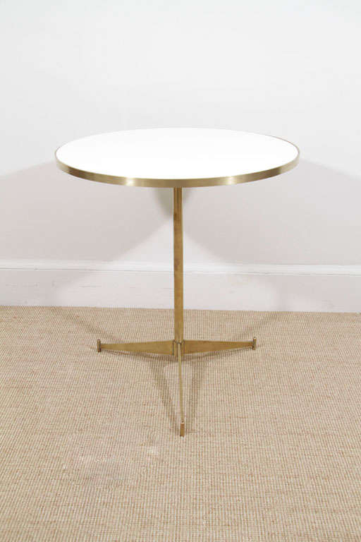 Each with slender space-age style tripod brass bases supporting circular white glass tops.