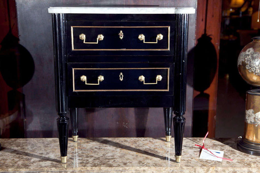 A finely polished diminutive ebonized salesman sampler two-drawer commode. Handmade with oak secondaries. A fine example with brass drawer frames and brass pulls. White marble-top by Maison Jansen.