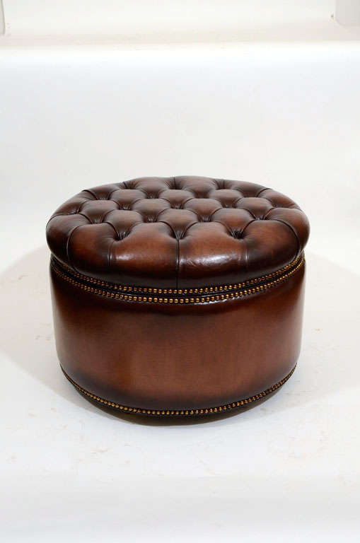 Pair of Round Tufted Leather Lift-Top Ottomans in Tobacco Brown Tones with Brass Tack Detailing, Interior Black Fabric Lining, and Raised on Casters. England, 20th Century

25 inches diameter x 17 inches high