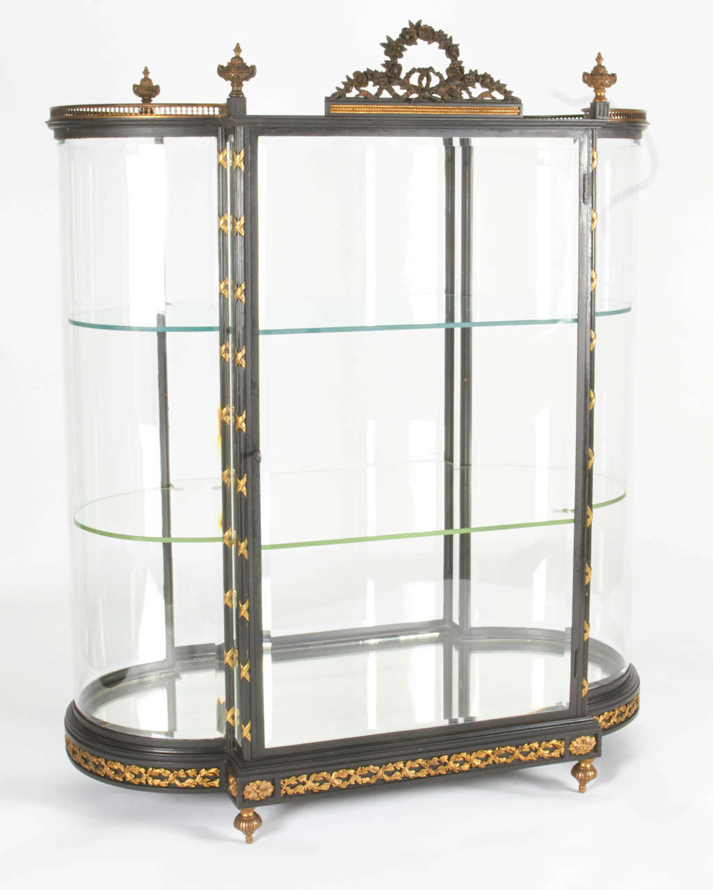 Belle vitrine à bijoux en bronze doré, bronze patiné, acier et verre, Paris, vers 1890-1910. Il est très inhabituel de voir ces vitrines ayant le verre incurvé d'origine, tout biseauté après plus de 100 ans, avec des étagères en verre d'origine et