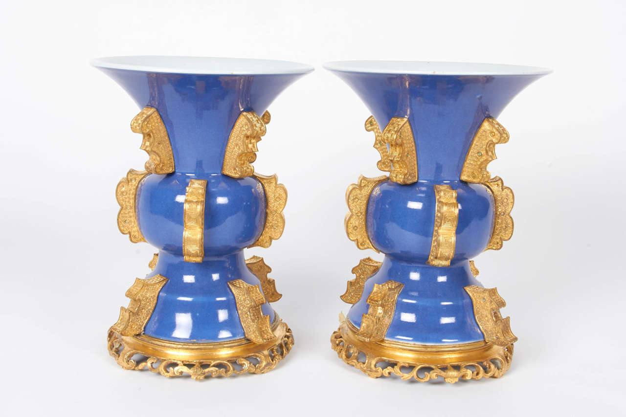 An unusual pair of antique Chinese blue poudre porcelain and Chinese gilt bronze-mounted vases in the ancient archaic Chinese style. These vases date to the late 1700s-early 1800s, in the Chinese archaic style and are extremely rare. The bronze is