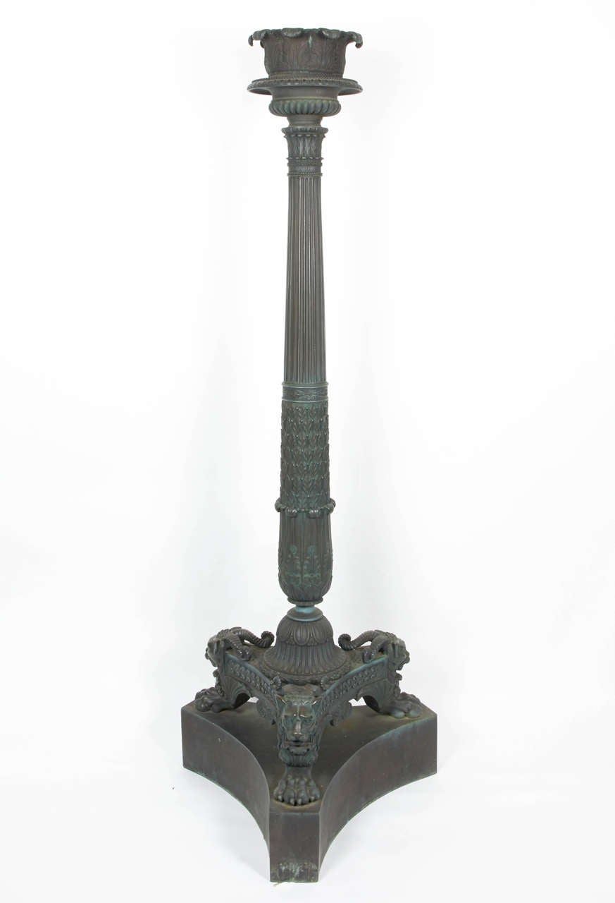 A rare pair of regency bronze green patinated tripod torcheres. Each with a laurel-clasped and fluted column with a circular acanthus top, on a concave-sided tripartite base with chimera monopodia supports and Plinth base.  First quarter of