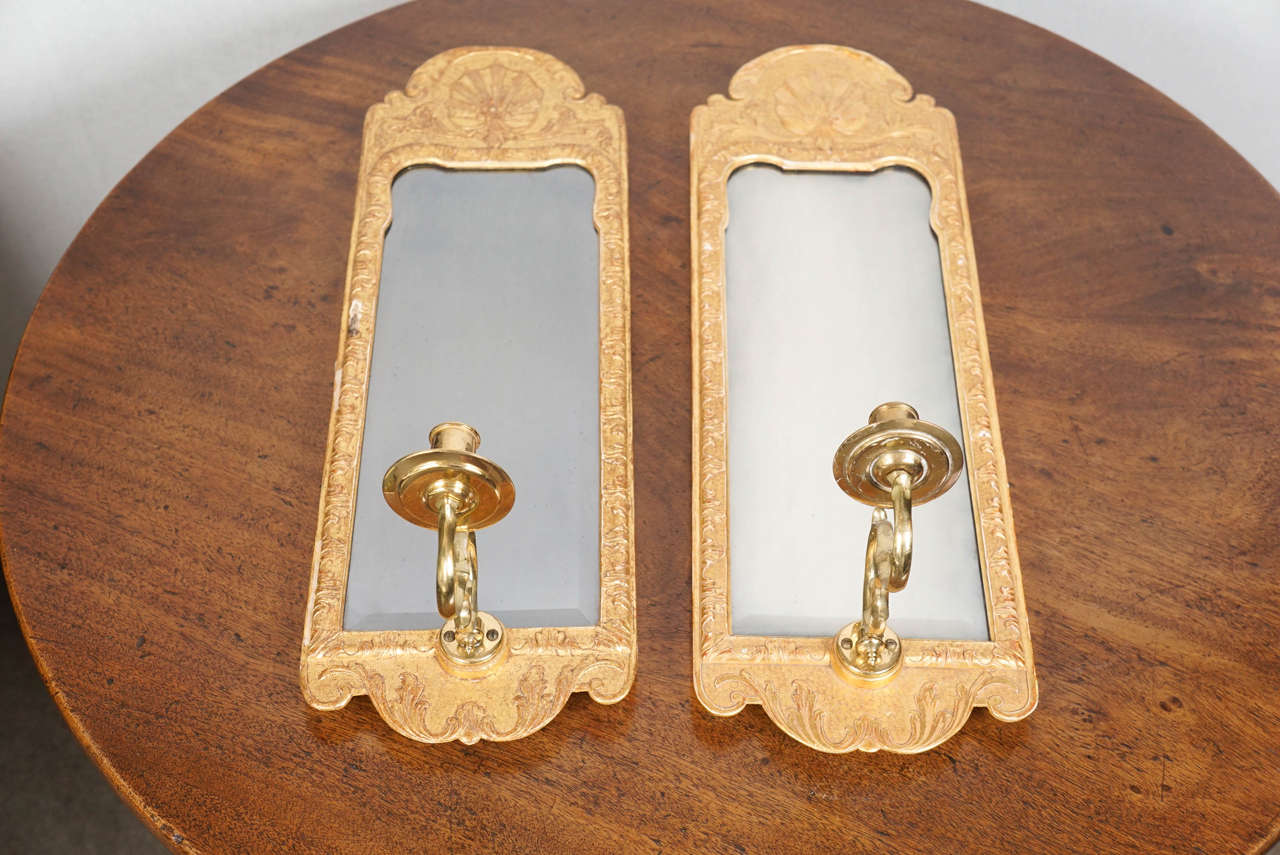 Set of four mirrored back and gilt sconces.