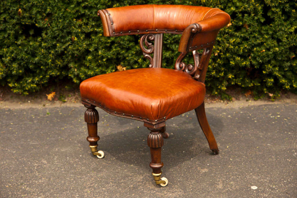 A mahogany William IV open pull-up chair with leather upholstery. Turned and reeded legs with original casters. Hand-carved back details.