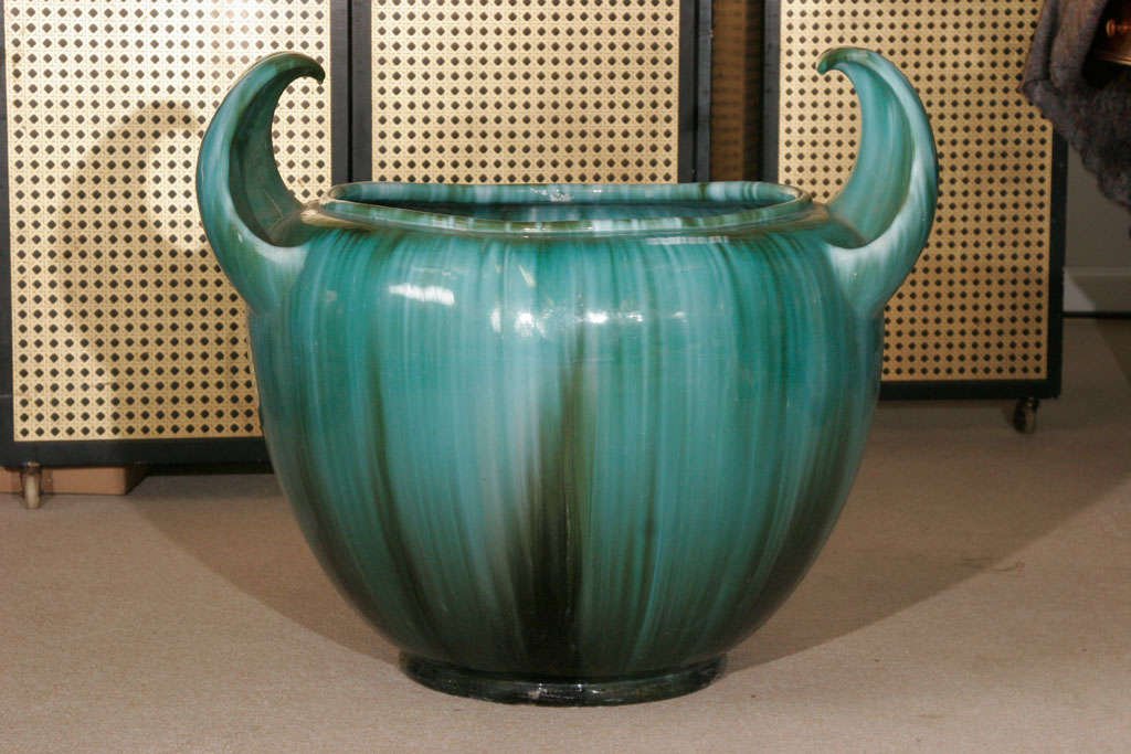 A large French Art Pottery Jardinière by Clement Massier. With upswept horned handles and covered in a turquoise and olive streaky majolica glaze.