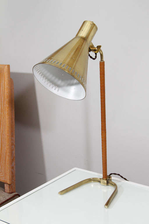 Elegant table lamp by Paavo Tynell for Taito Oy. brass finish with leather wrapped stem.