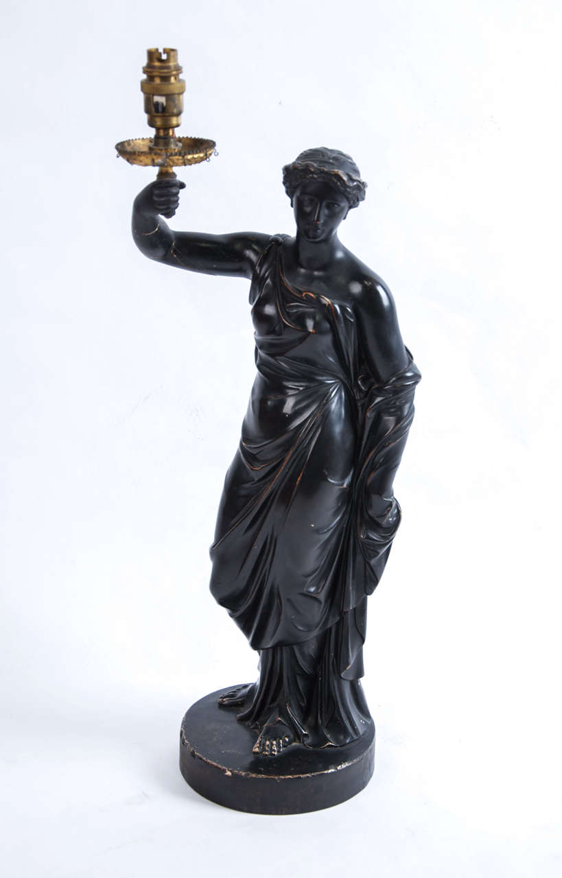 Classical maiden Regency lamp base in ebonized plaster holding up an ormolu light fitting, (later adapted for electricity, comes wired with black fabric cable with an inline switch, UK plug) the back inscribed January 1st 1816 H Hopper London.