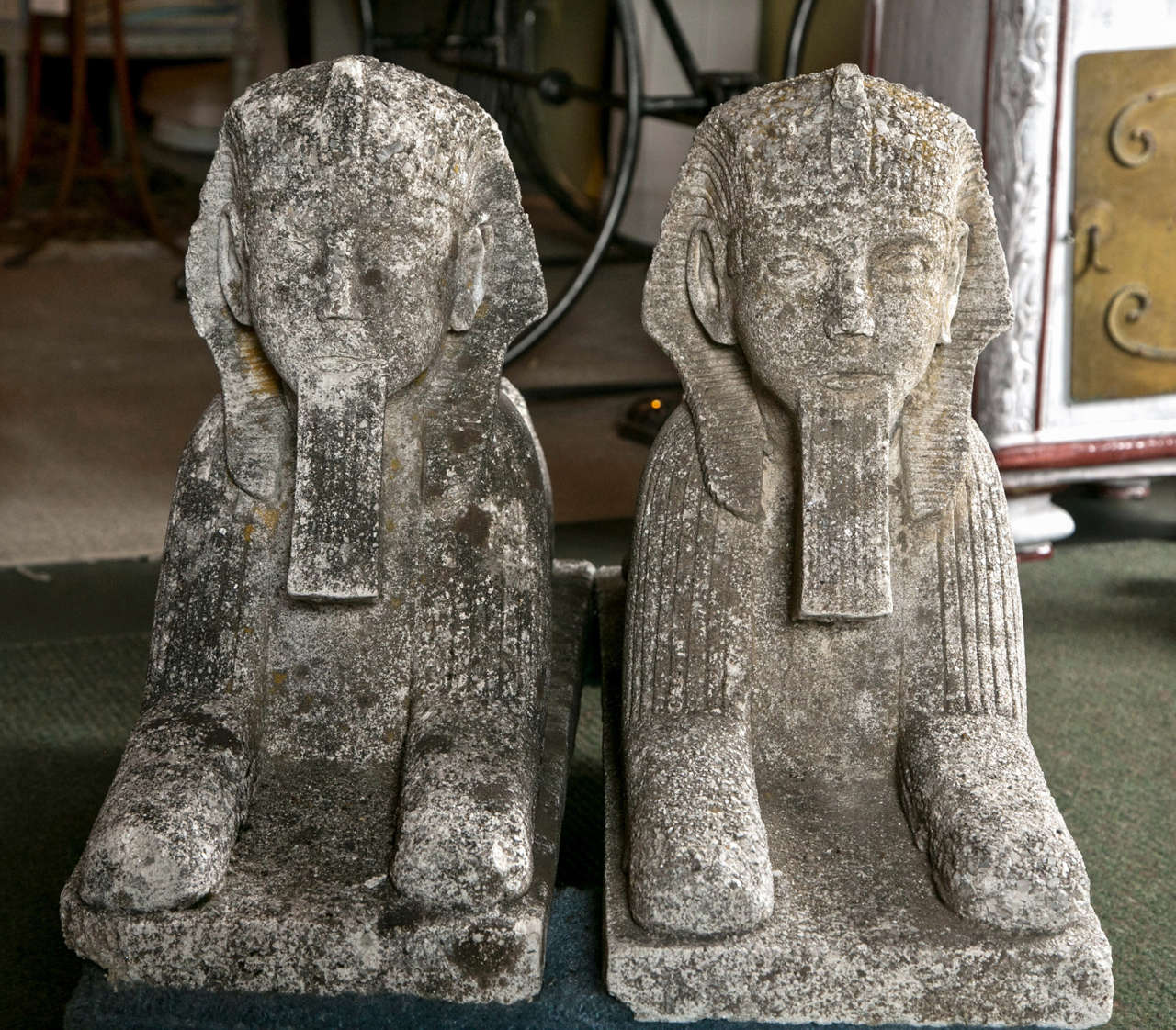 A pair of cast stone sphinx garden ornaments.