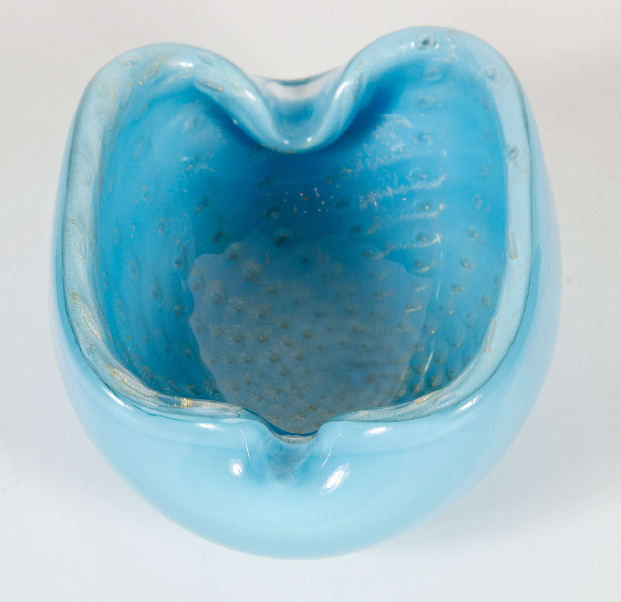 Exquisite hand blown Murano glass bowl in a robins egg blue with an ovoid shape.  It has a polished design on the outside while the inside is speckled with 24K gold flecks in a starburst pattern.