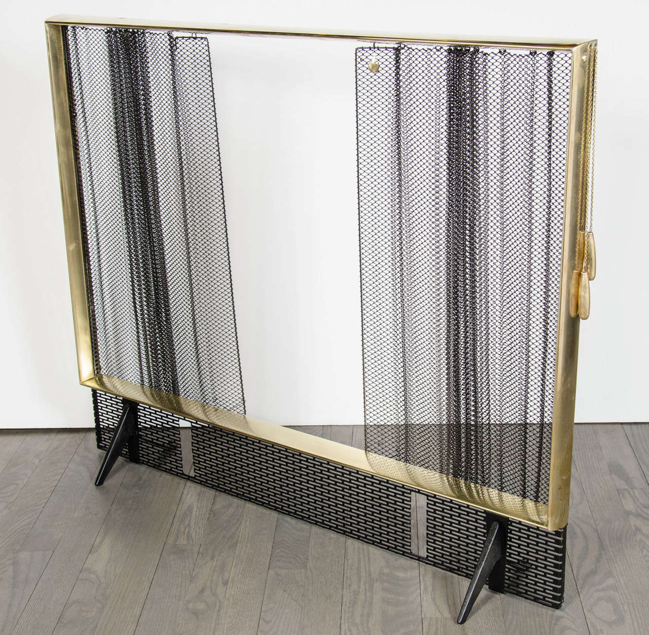 This exceptional Art Deco Fire Screen by Donald Deskey for Bennett features a center opening chain operated mesh curtain on a polished brass frame and a spark arrester with andiron slots.
Matching Andirons and fire tools available. Contact dealer