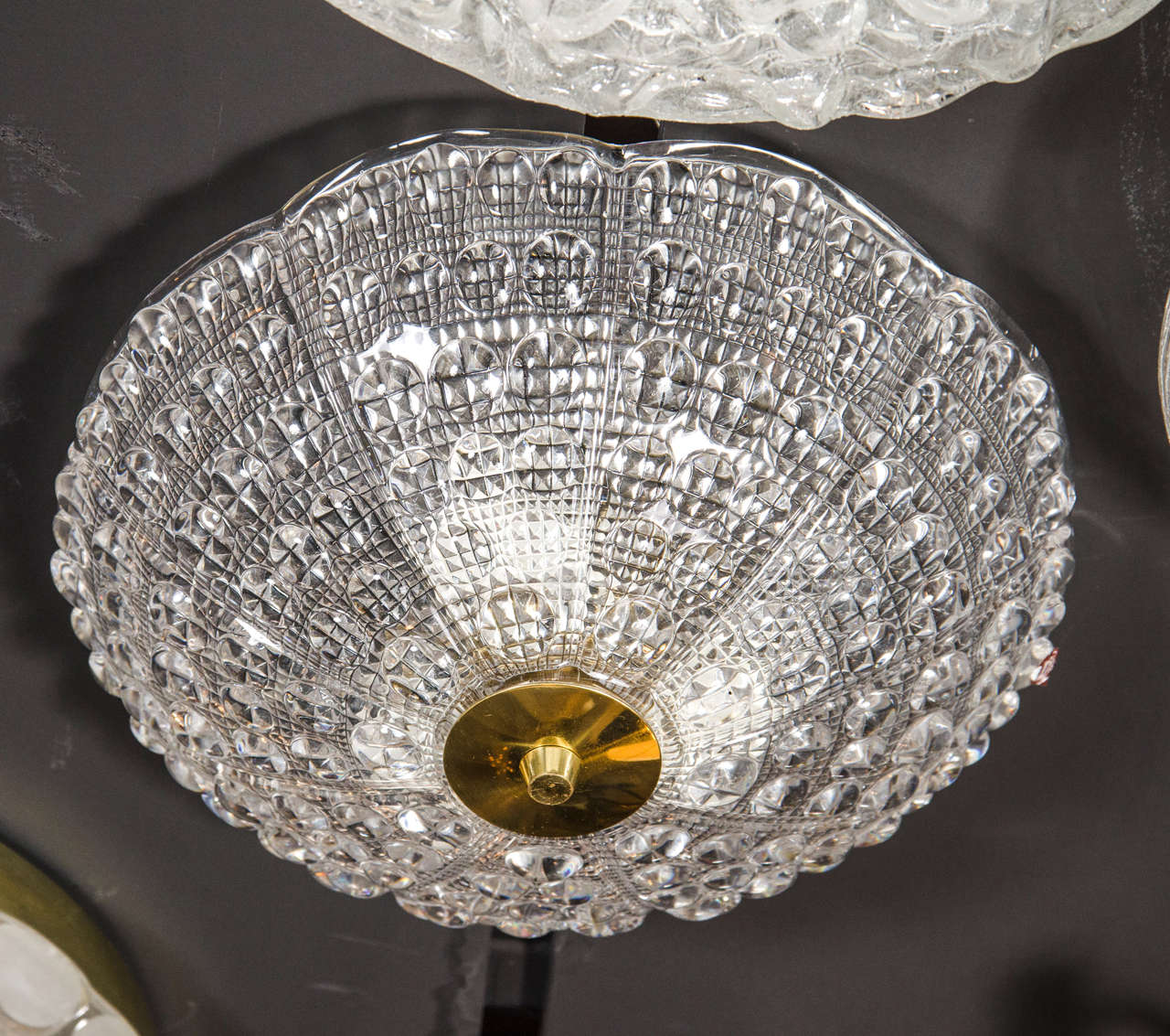 This elegant midcentury flushmount chandelier was designed by the legendary Carl Fagerlund for Orrefors in Sweden, circa 1960. It features a stunning pressed glass dome with a subtly scalloped top and a wealth of organic texture through with a