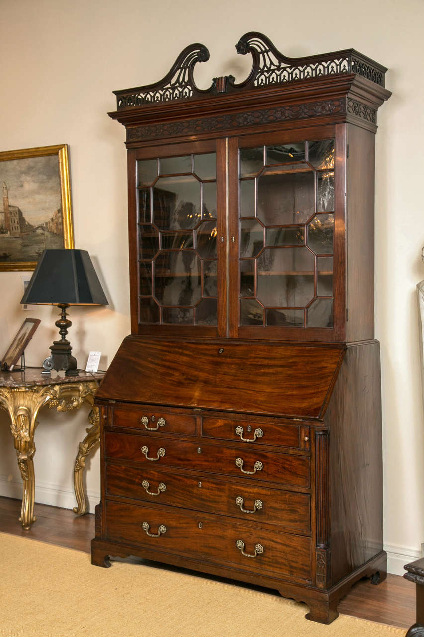 An exceptional quality George III mahogany Chippendale secretary bookcase,
With a swan neck fret carved cornice above astragal doors. The fall front exposing a fine interior with secret compartments centered with a mirrored door, flanked by canted
