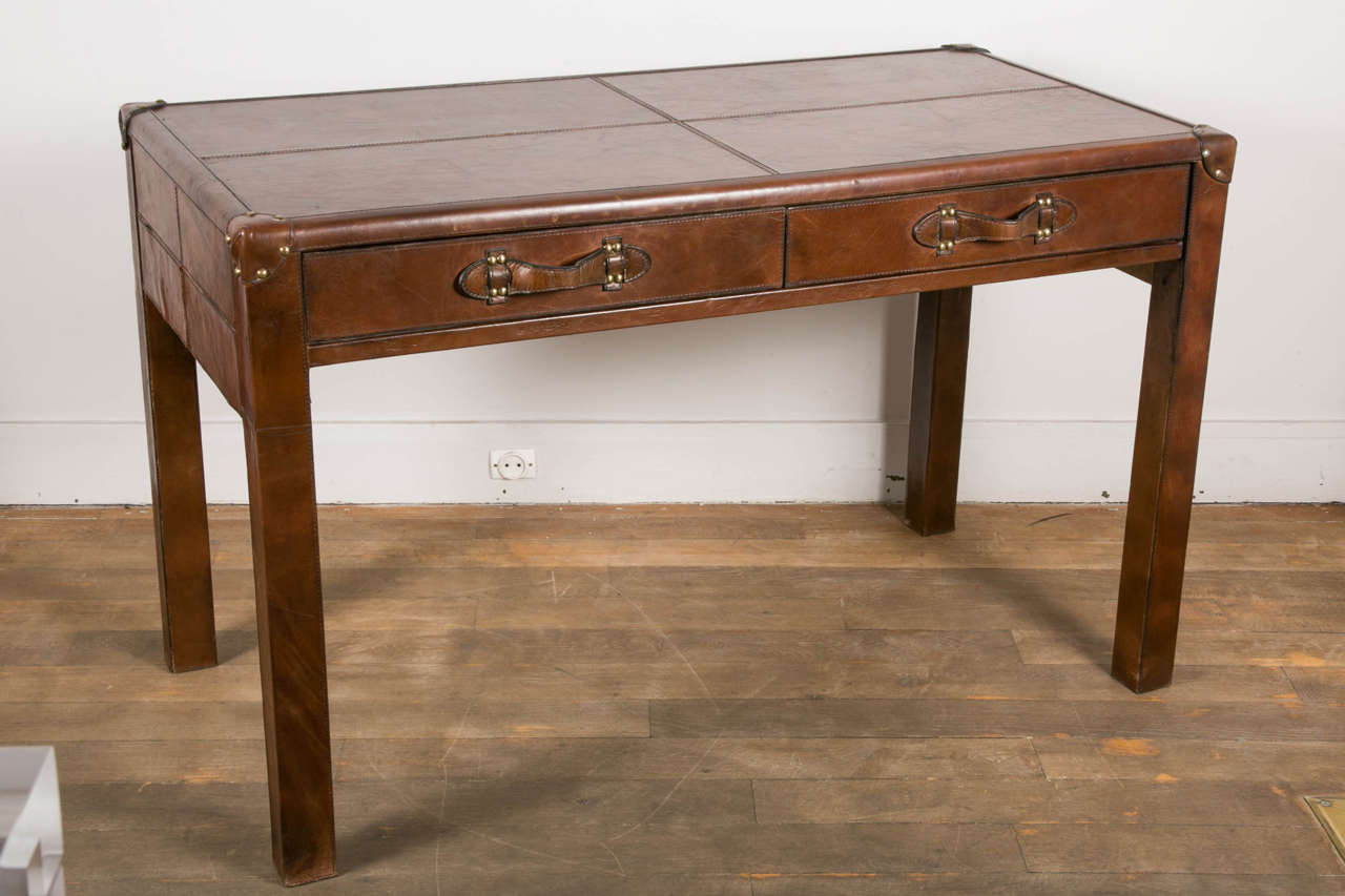 A brown leather desk opening by two drawers.
Entirely covered with brown leather with nice patine.
France, circa 1970.