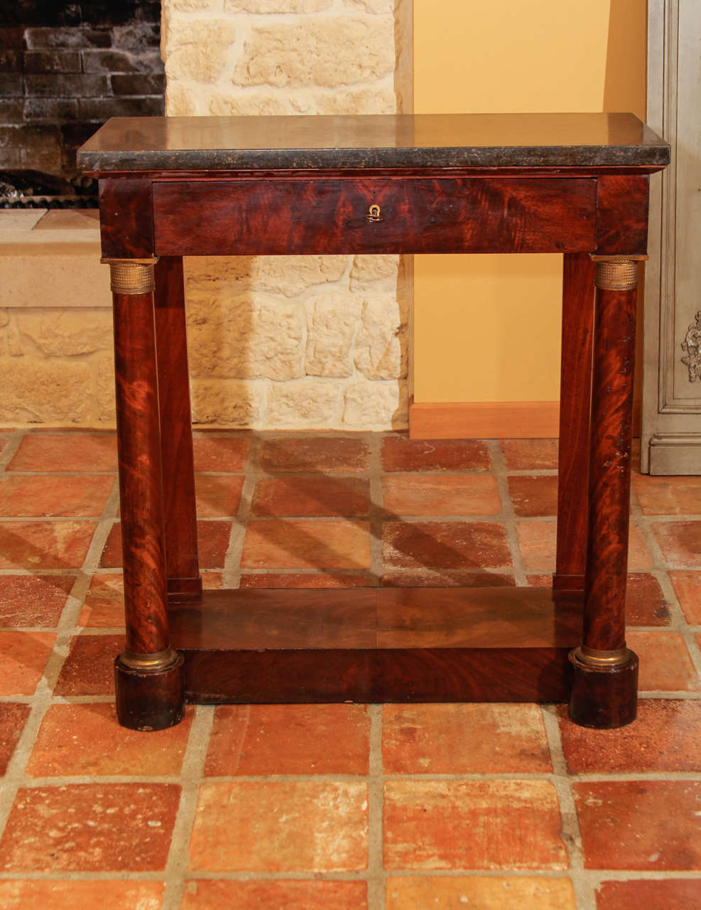 French Empire mahogany console table.

This is a diminutive French 1st Empire period console with the original Belgium black marble top. It features beautiful Honduran mahogany veneer that is bookmatched. 

It has a dove-tailed case with a full