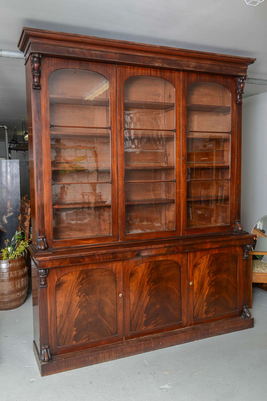 Large cabinet, hand crafted in mahogany, with three upper sliding glass doors over three flat panel doors of crotch mahogany.  Upper section has adjustable shelves & lower portion has one shelf in each of the three sections.  Beautifully restored