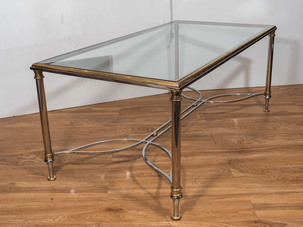 A vintage brass rectangular coffee or cocktail table with elegant chrome base and glass top. Good condition, wear consistent with age and use.

There is damage to the glass on one corner.