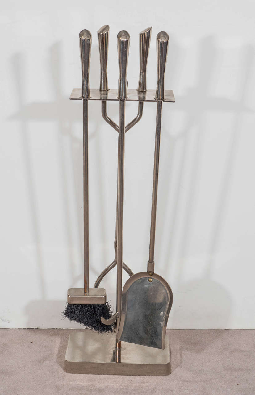 A vintage set of fireplace tools with Stand, produced, circa 1950s, in polished chome. Tools include: Broom, shovel, poker and tongs. Good vintage condition with age appropriate wear and slight patina.