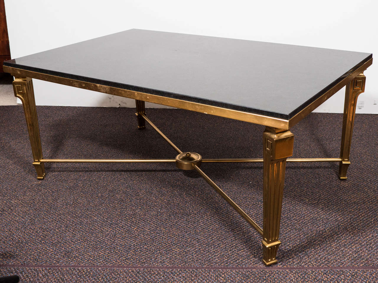 A vintage Art Moderne style coffee or cocktail table by Maison Jansen, Heavy Black marble-top and bronze frame on fluted legs with Greek keystone designs, spread by X-stretcher. Fantastic Coffee Table that is Made like a fine Piece of Estate Jewelry.