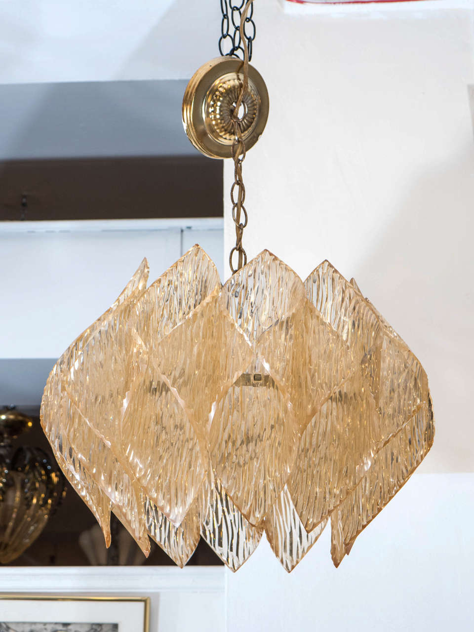 A vintage Kalmar style chandelier on a metal frame with a shade made of folded amber colored acrylic. Good vintage condition with age appropriate wear and patina.