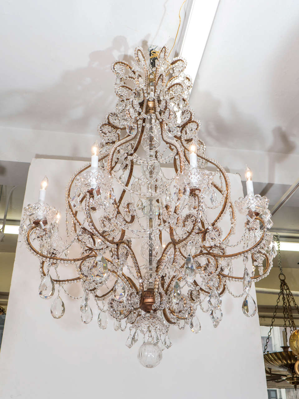 A large Midcentury Italian brass chandelier with crystal drops and bead-work. This chandelier is in good working condition with US standard wiring and takes nine candelabra base bulbs. Good vintage condition with age appropriate wear.