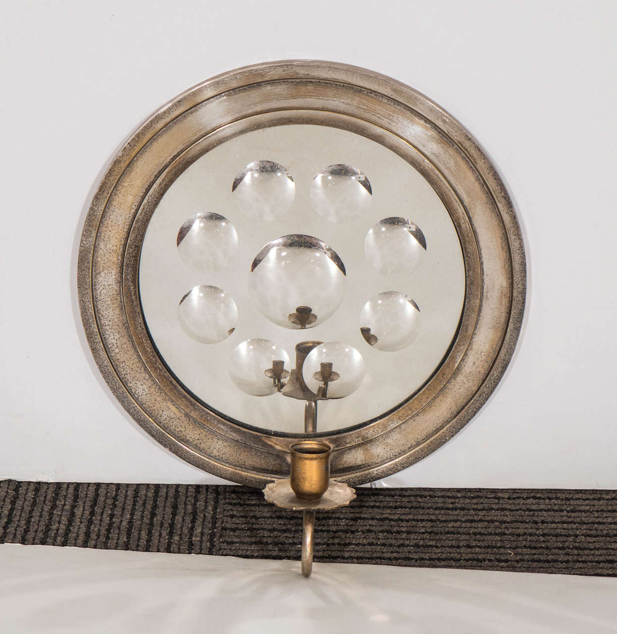A vintage pair of round, mirrored sconces with raised circular accents, chrome frames and candle holders, attributed to designer Piero Fornasetti. Vintage condition, with loss of finish, the chrome somewhat patinated.