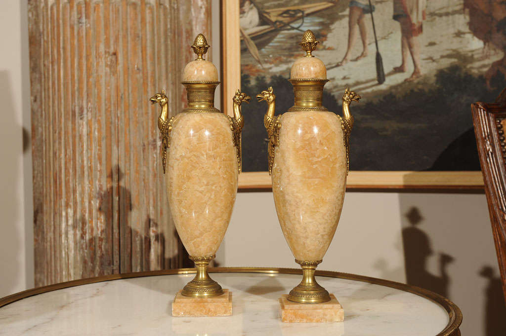 1st quarter 20th century pair of ecru travertine crystalized marble garniture vases of classic form with gilt bronze ormolu mounts on stepped bases.