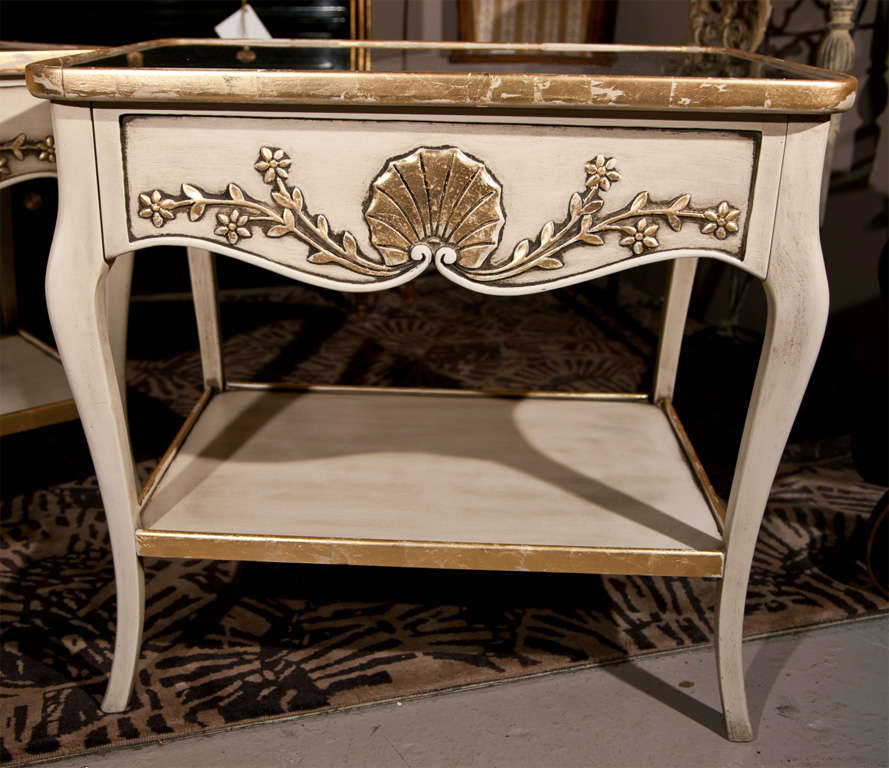 Pair of French Louis XV style end tables, circa 1950s, overall painted and parcel-gilt, Plexiglas top over a frieze fitted by a single drawer decorated with shell crest and foliate, raised on cabriole legs joint by a lower tier.