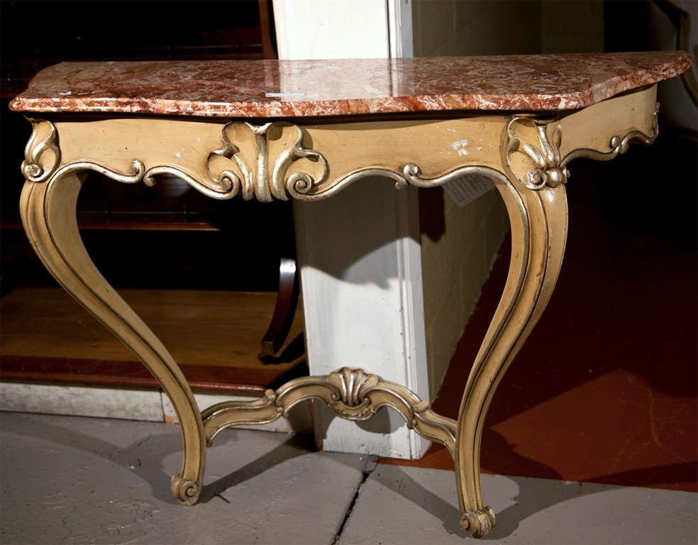 French Rococo style console table, circa 1940s, serpentine red and white veined marble atop a beige distress-painted base, parcel silver-leaf, raised on cabriole legs. Requires wall mount.