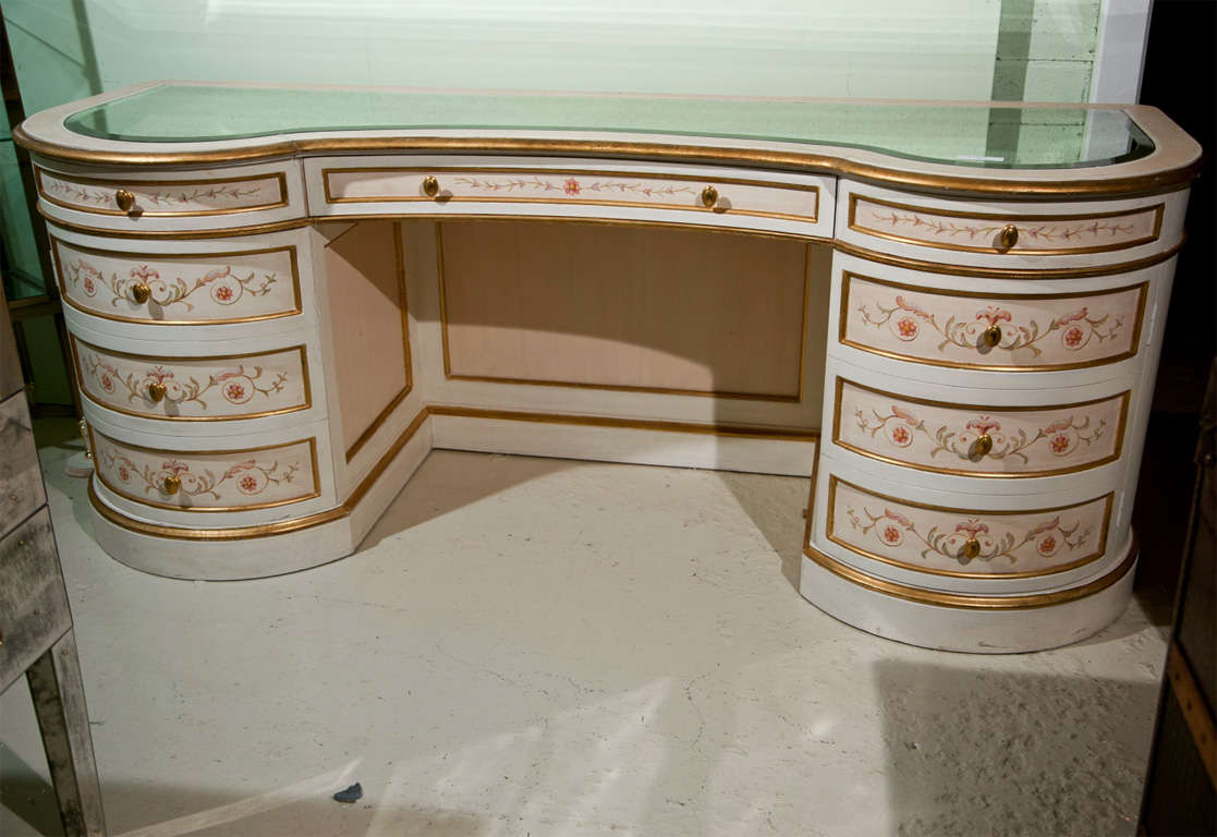 A very charming French hand-painted vanity table, the glass inset on a kidney-shaped top, over a narrow frieze fitted with a single drawer, flanked by two pedestals, each has a drawer over a half-moon cabinet, raised on block base.