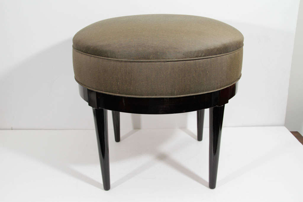 Modernist Mid-Century Ottoman by Robsjohn Gibbings. Ottoman is newly upholstered in silk blend upholstery with matched piping and features ebonized Walnut tapered legs.