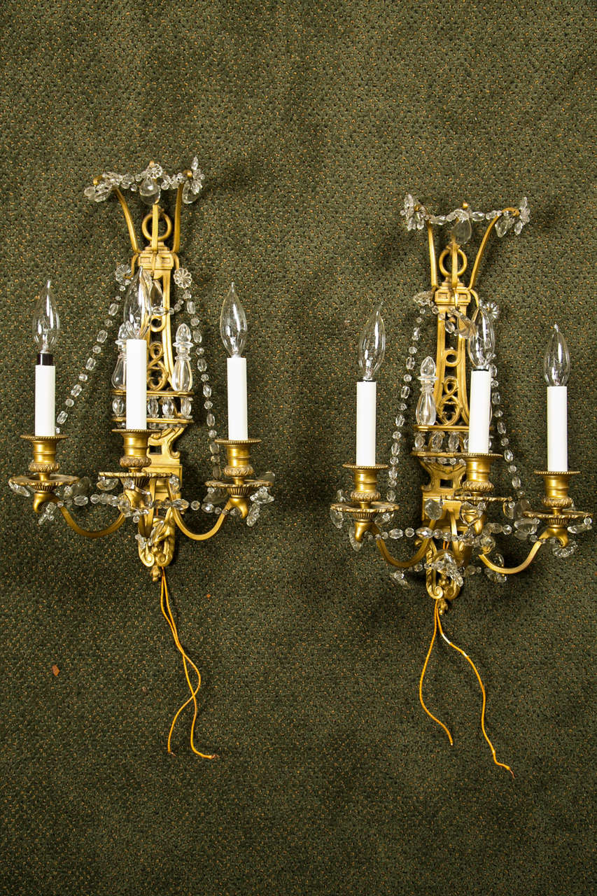 A pair of fine quality French bronze dore and crystal, three light sconces.