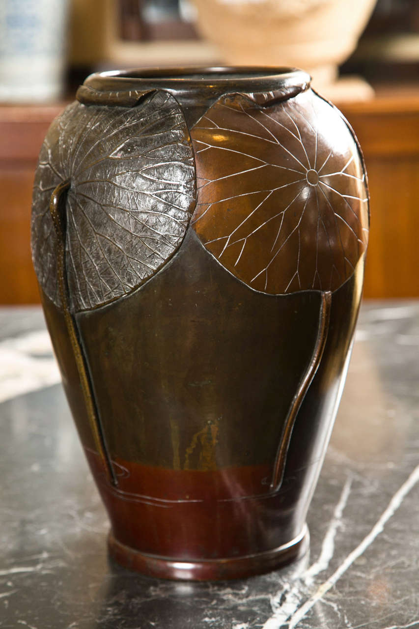 A Japanese patinated bronze vase with alternating lotus leaf design.  Meiji Period