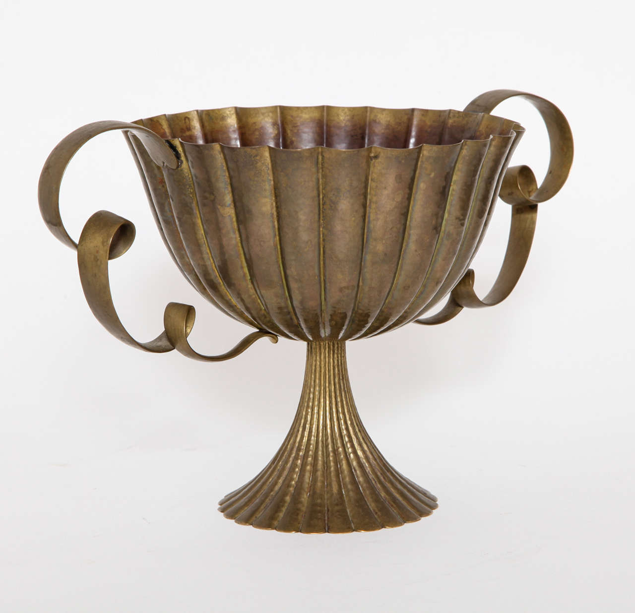 A Josef Hoffmann brass, hand-hammered two-handled bowl, executed by the Wiener Werkstatte, 1925. The hammered fluted bowl with elaborate scrolled handles and trumpet stem are in original unpolished condition. The Josef Hoffmann monogram, 
Wiener