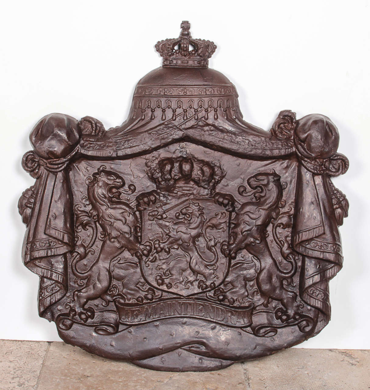 Unique cast iron plaque representing the coat of arms of the Netherlands. The shield is topped with the Dutch royal crown and supported by two lions standing on a scroll. The banner reads "Je Maintiendrai," French for "I will