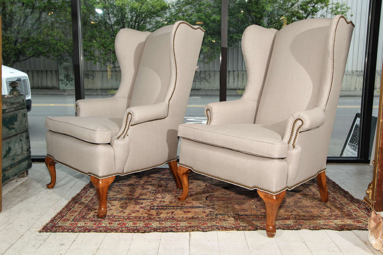 pair wingbacks in new grey linen upoholstery trimmed in nailheads.   these chairs have great lines from every direction