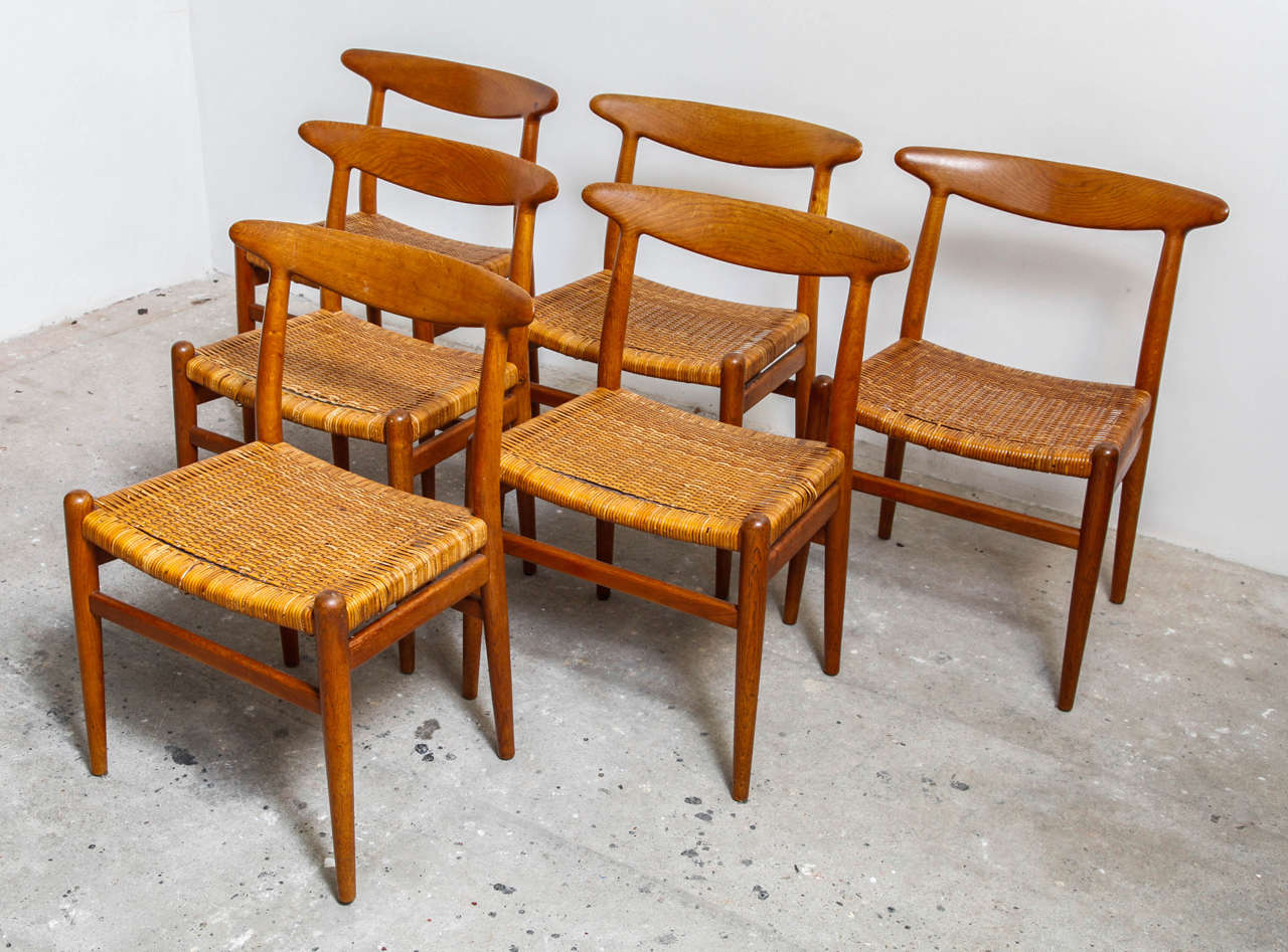 Set of six W2 chairs designed by Hans J. Wegner made by C. M. Madsens in Denmark, 1953. 
Made from solid teak with rattan seats, these teak chairs are in an original good vintage condition. The rattan is damaged on the edge of the wood and restored