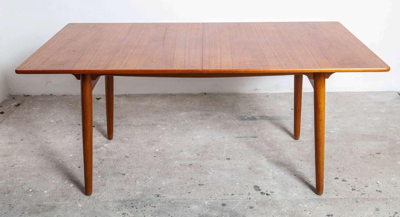 Dining table designed by the Architect Hans J. Wegner for Andreas Tuck, circa 1955 model -AT 310.
The table has solid oak legs and base with a teak top in very good vintage condition.
The table has two extension leaves of 40 cm each, bringing the
