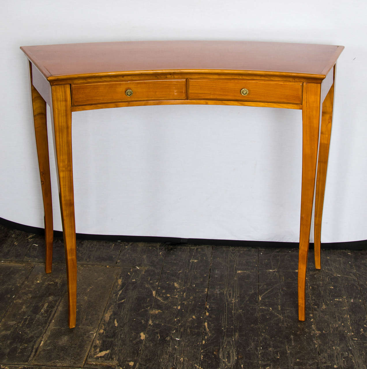 1940s Italian curved little writing table in walnut with two drawers and nice ornamental brass handles.