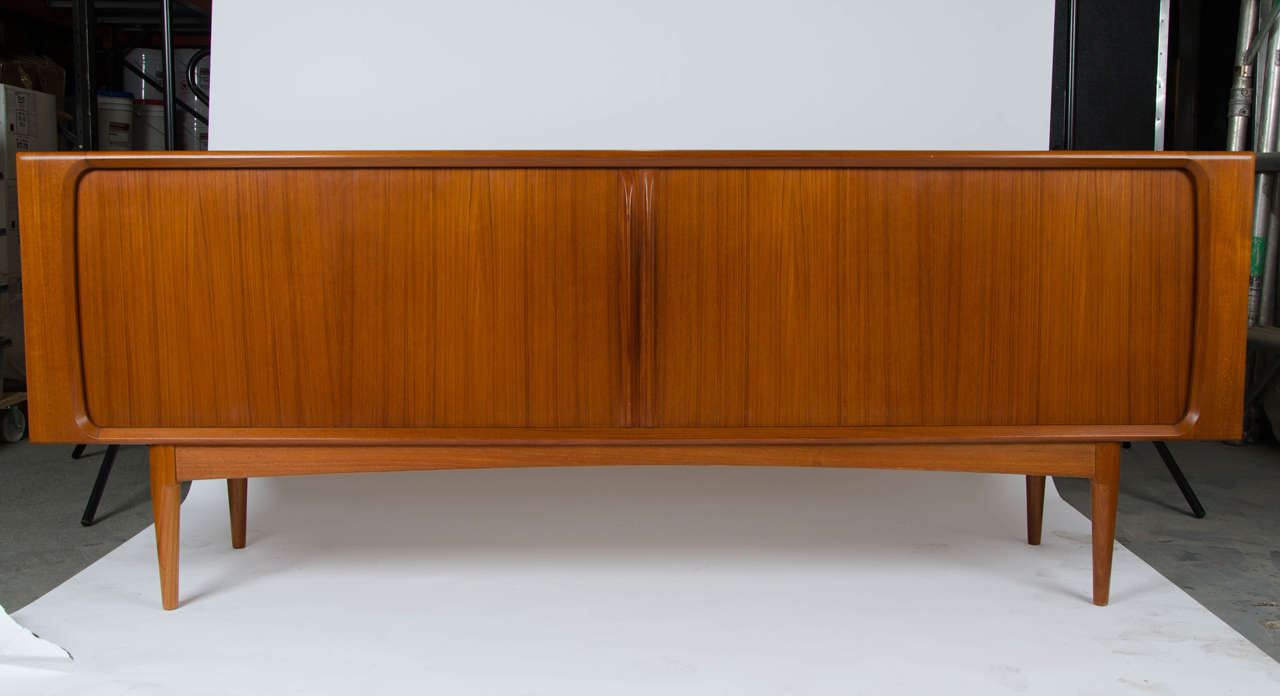 A beautifully crafted sideboard, designed by Hos Wulff for Danish Manufacturer Bernhard Pedersen & Son, Denmark. The cabinet features smooth operating tambour sliding doors to reveal three drawers and three adjustable shelves. All round excellent