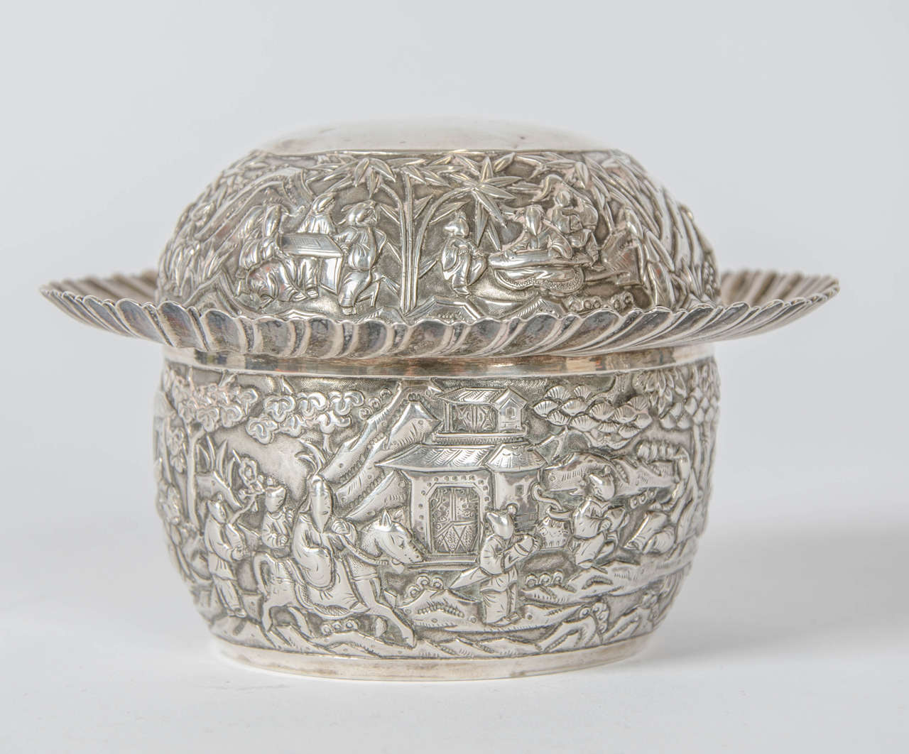 A 19th century Chinese export silver bowl and cover manufactured by Wang Hing of Canton. The bowl and cover are profusely hand chased with detailed images of Chinese scenes. Hallmark struck on the base of the bowl ( Wang Hing ) The weight of the