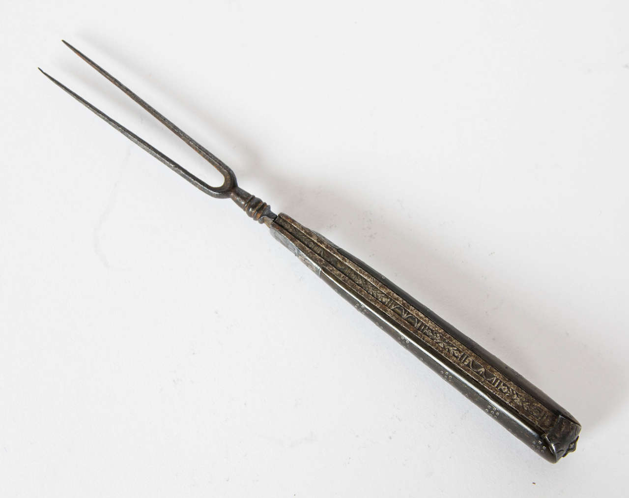 A very rare English Carolean period (1660-1685) folding two pronged Campaign fork. The tines are steel and the handle is made from cow Horn with applied silver floral motifs and pique work. There is a very detailed scroll motif along the steel spine