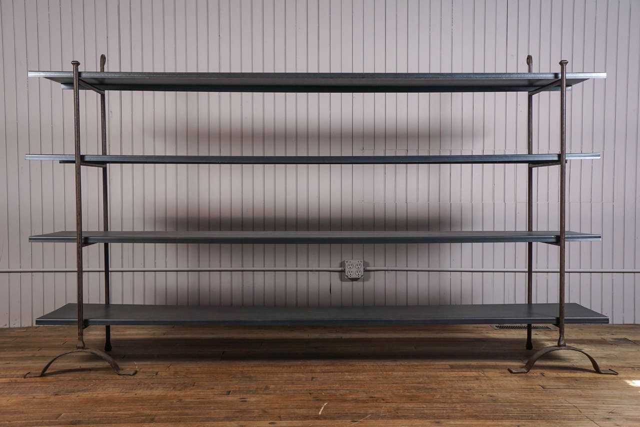 Four 8' long metal shelves, creased edging for added strength, float on wrought iron adjustable stanchions.