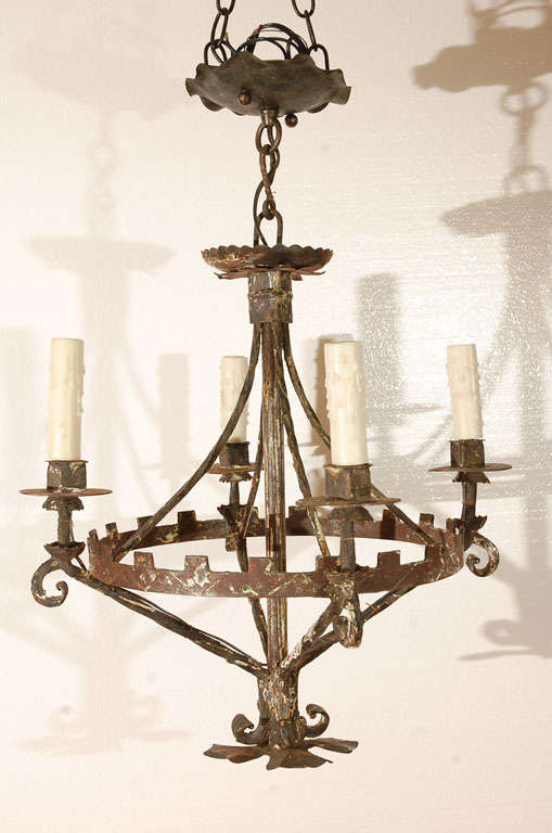 Hand wrought iron chandelier with four lights, probably American, rewired. Hand wrought and circular frame with chased design. Unusual square candle cups. Chandelier measures 20