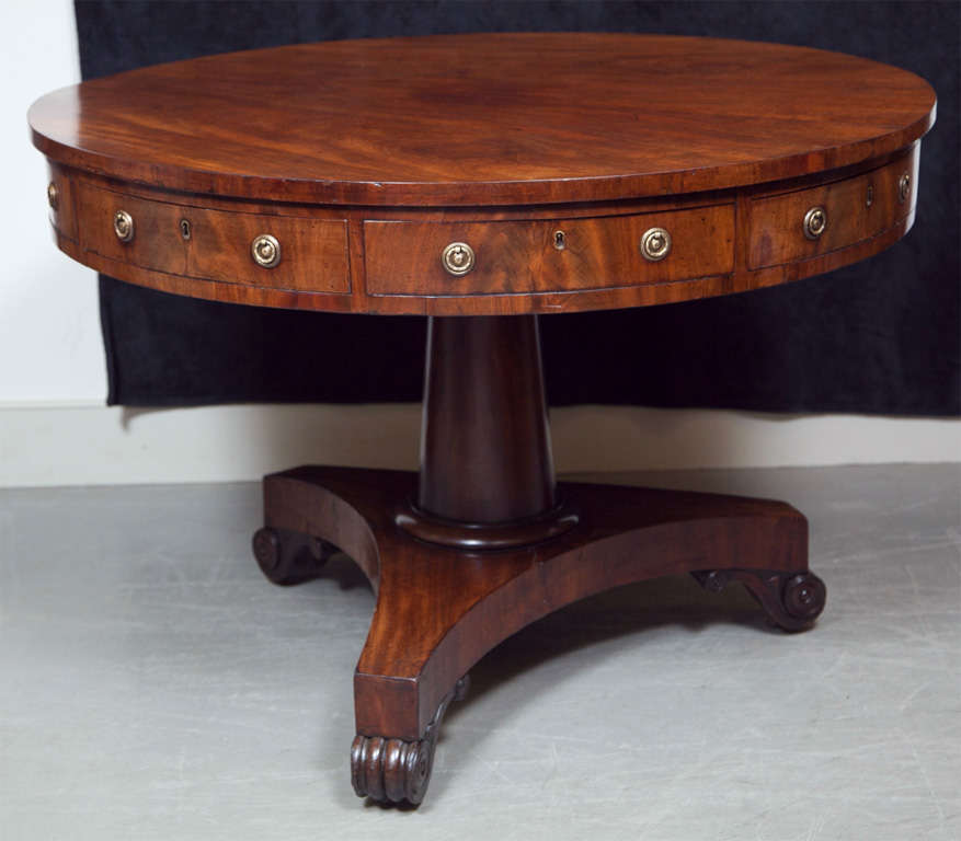 This is a superb example of an English mahogany drum table. The handsome grain has achieved an incredible patina-the rich, warm tone of the wood is barely captured in these photos, one must see this table in person to truly appreciate the color. The
