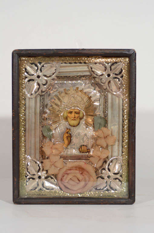 Outstanding antique Russian icon mounted in original wood and glass shadowbox frame. Depicts Saint Nicholas comprised of repousse technique, whereby metalworking is done by hand on the reverse side creating designs in low relief. Features