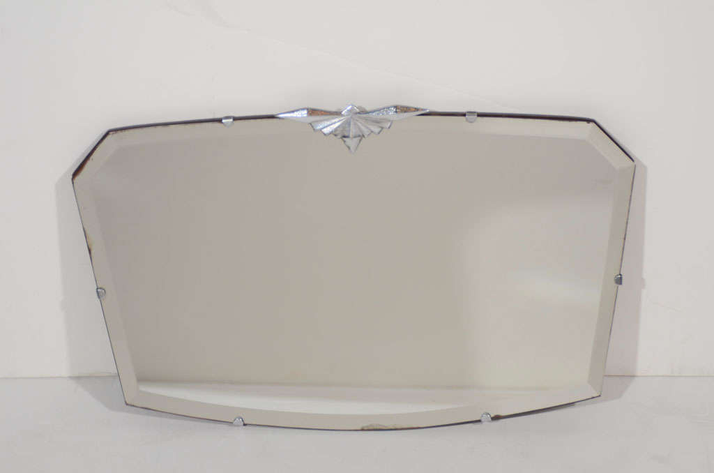 Small Art Deco mirror with modern
hexagon design. Has hand beveled
borders and a stylized skyscraper
chrome fitting on the top center,
reminiscent of the Chrysler Building.
Perfect scale for a hallway, dressing
room or as a vanity mirror for